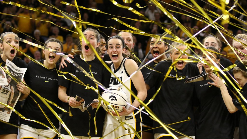 Caitlin Clark surrounded by her teammates as banners rain down