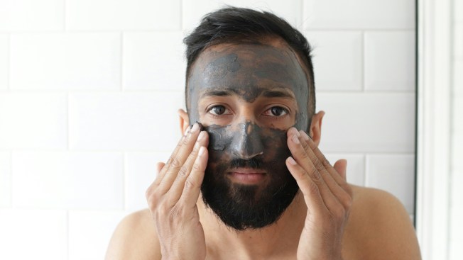 man applying facial mask